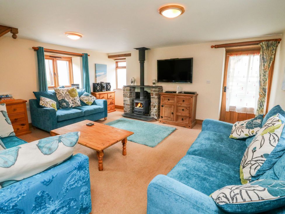 A living room with sofas and a fireplace at The Shippon in Barnstaple