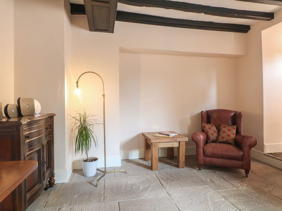 A living room with an armchair and side table at Hambleton House, Castle Donington