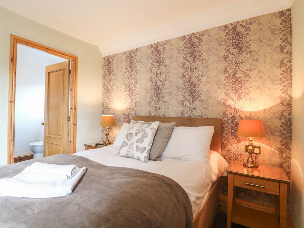 A bedroom with a bed and bedside table at Hambleton House in Castle Donington