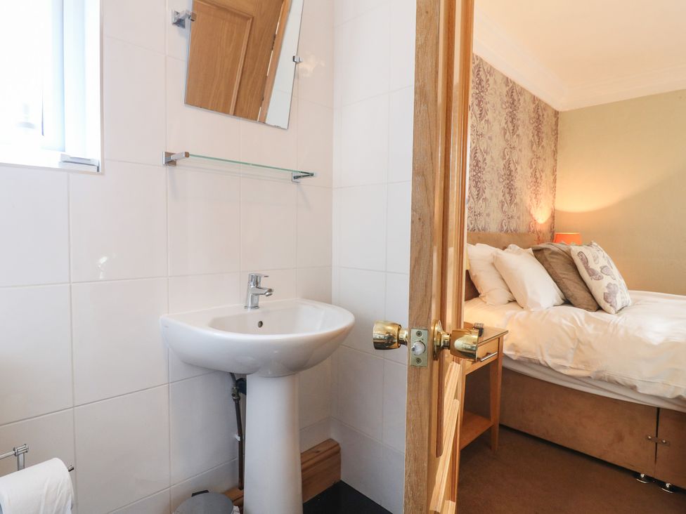A bedroom with a sink and a mirror at Hambleton House in Castle Donington