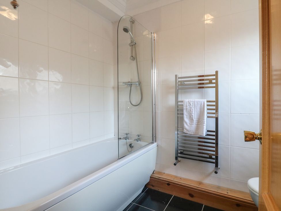 A bathroom with a bathtub and towel rail at Hambleton House in Castle Donington