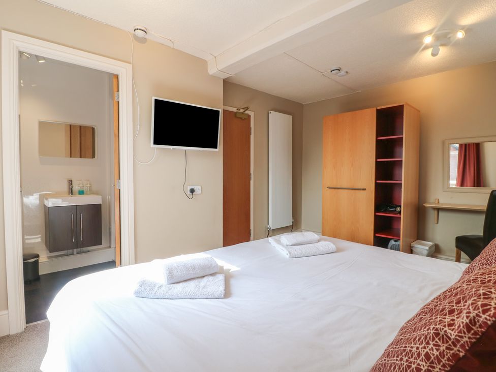 A bedroom with a bed and television at Hambleton House in Castle Donington