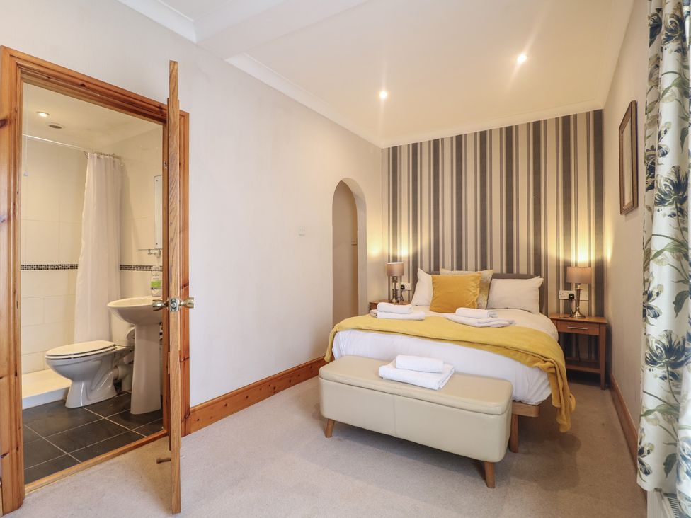 A bedroom with a bed and an attached bathroom at Hambleton House Castle Donington