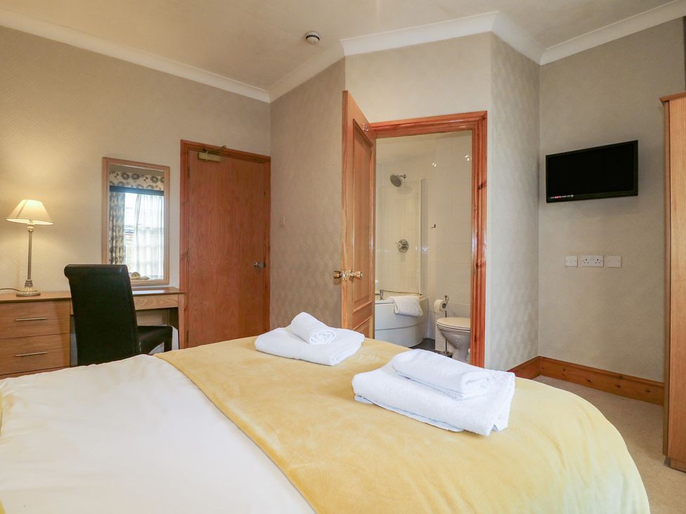 A bedroom with a bed and a desk at Hambleton House in Castle Donington