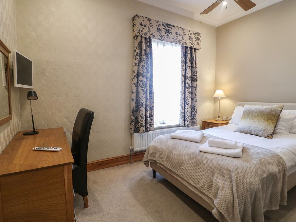 A bedroom with a bed, desk, and television at Hambleton House in Castle Donington