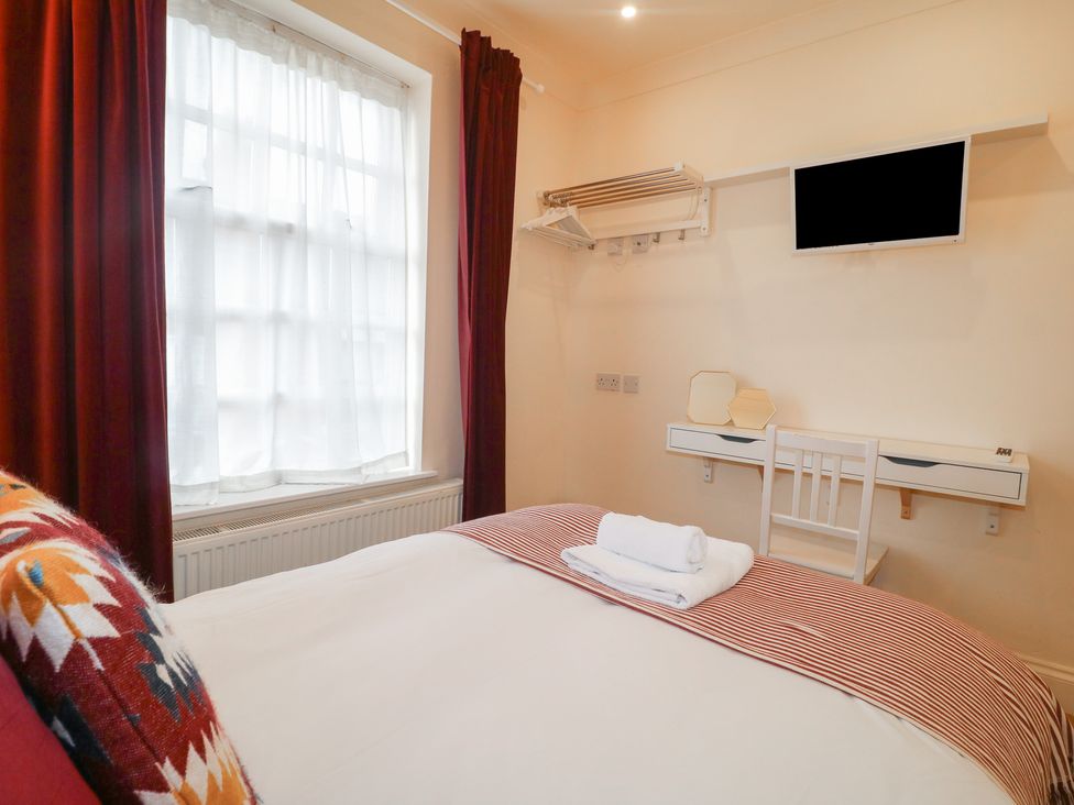 A bedroom with a bed and wall-mounted TV at Hambleton House in Castle Donington