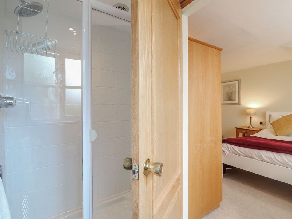 A bathroom with a shower and adjoining bedroom at Hambleton House, Castle Donington