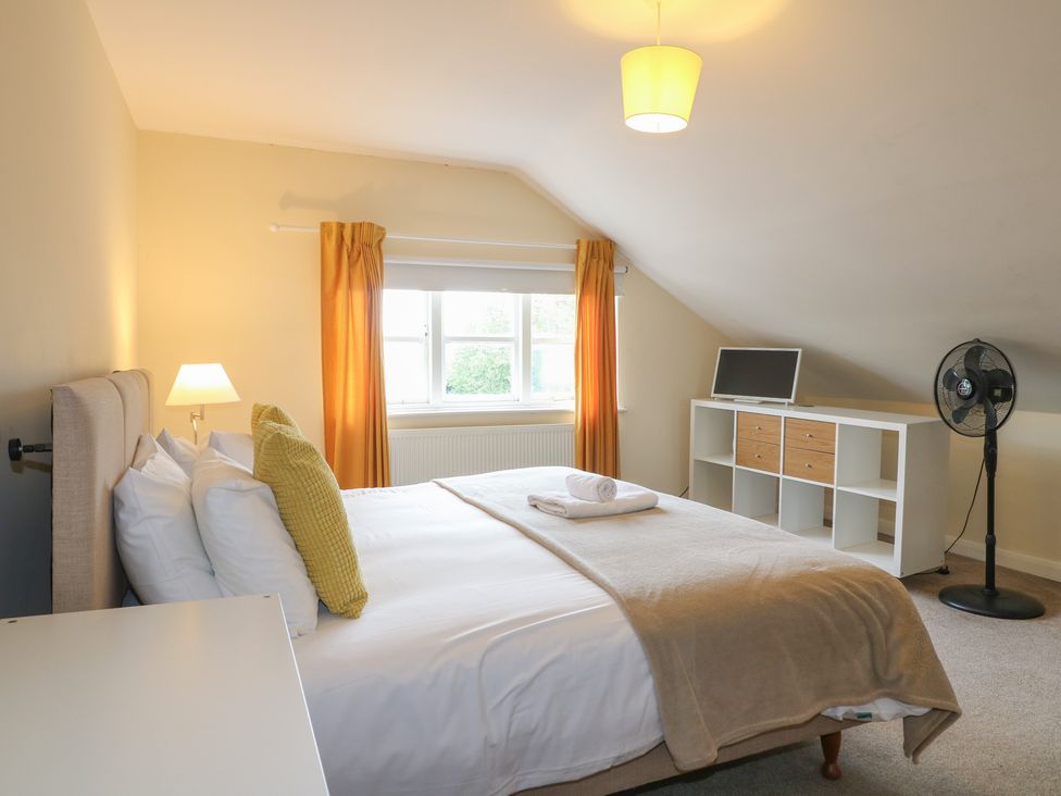 A bedroom with a bed, television, and shelf unit at Hambleton House in Castle Donington