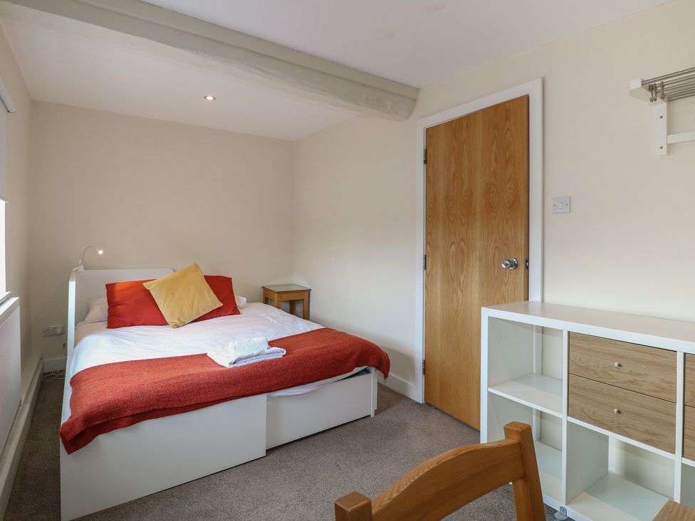 A bedroom with a bed and storage unit at Hambleton House Castle Donington