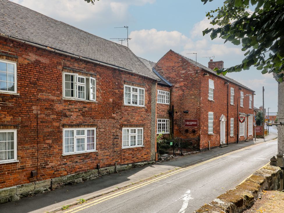 A brick building with windows and a sign at Hambleton House in Castle Donington