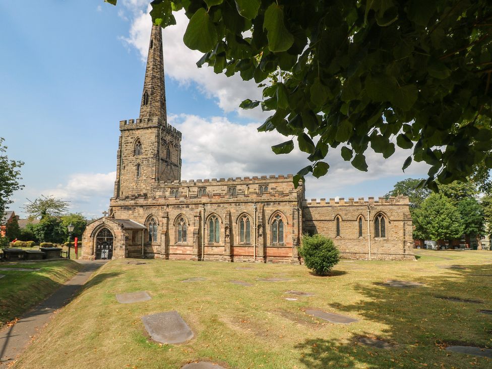 A church with a steeple and surrounding graveyard at Hambleton House in Castle Donington