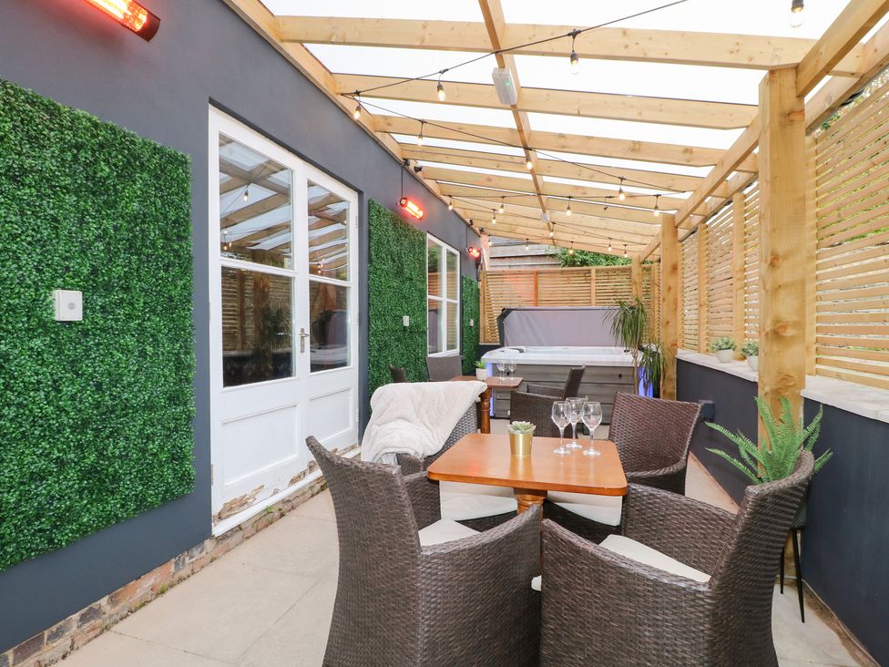 An outdoor living area with a table and chairs at Hambleton House in Castle Donington