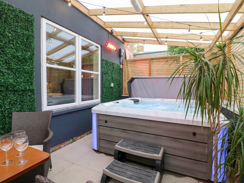 An outdoor area with a hot tub and seating at Hambleton House in Castle Donington