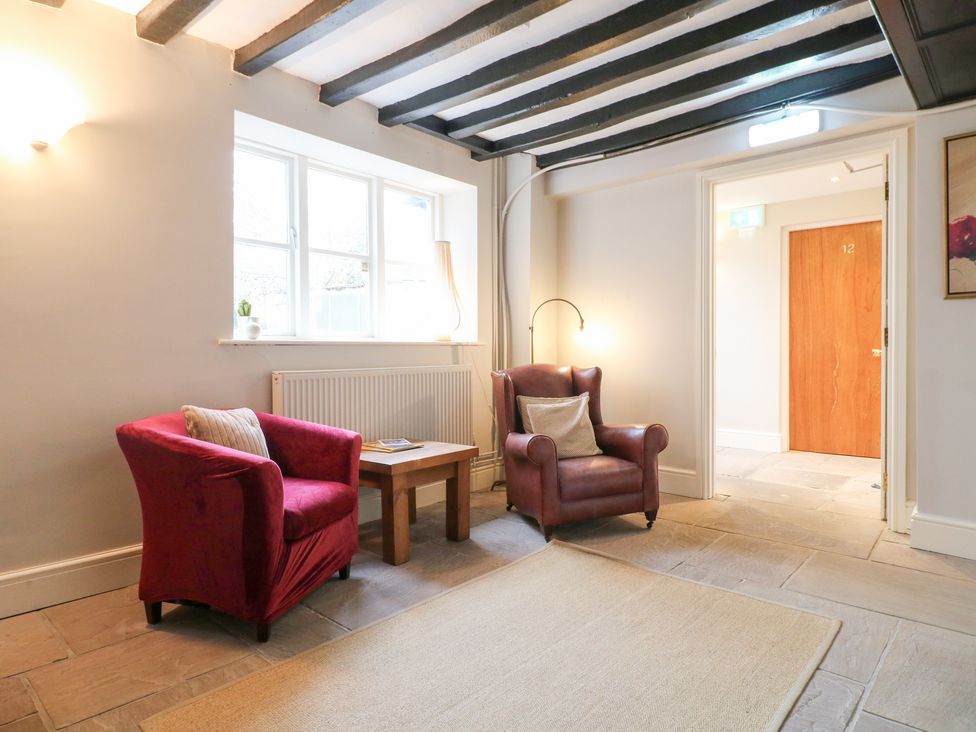 A lounge with two armchairs and a wooden table at Hambleton House in Castle Donington
