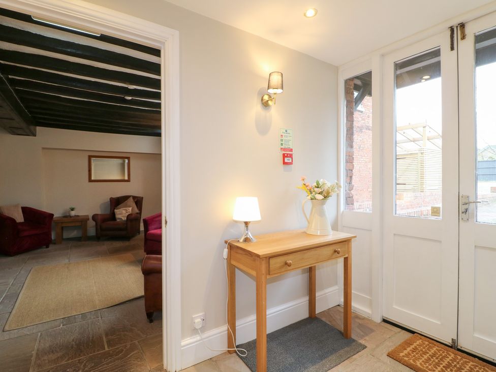 A hallway with a table and lamp at Hambleton House in Castle Donington