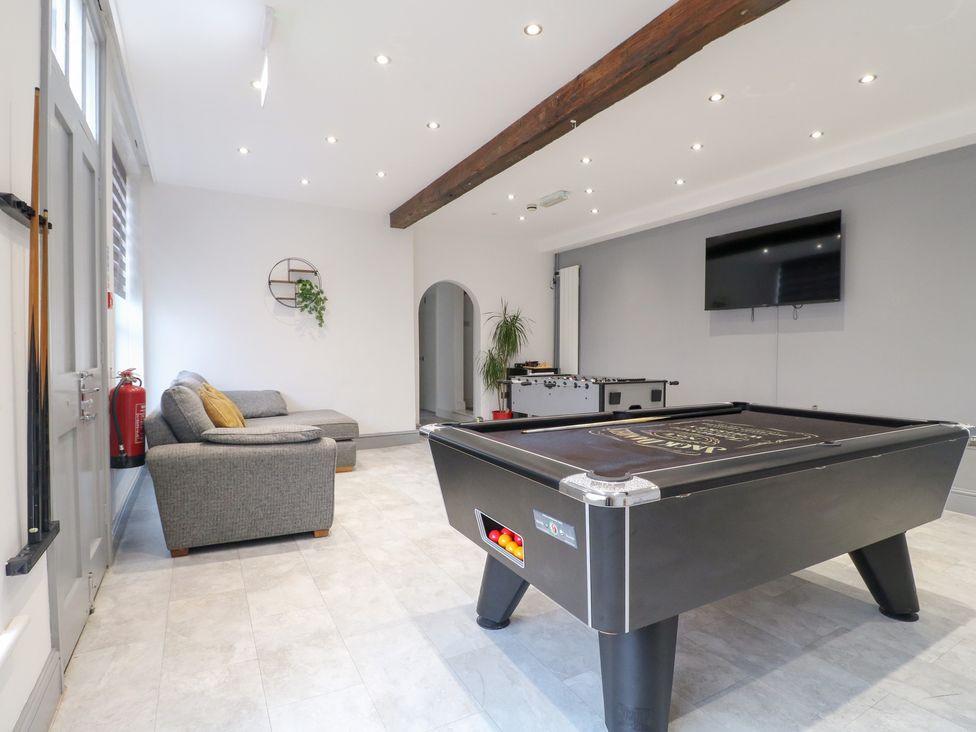 A recreation room with a pool table and sofa at Hambleton House in Castle Donington