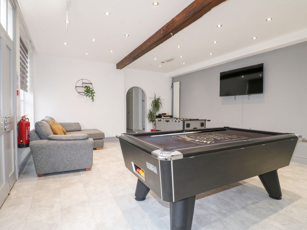 A game room with a pool table and sofa at Hambleton House in Castle Donington