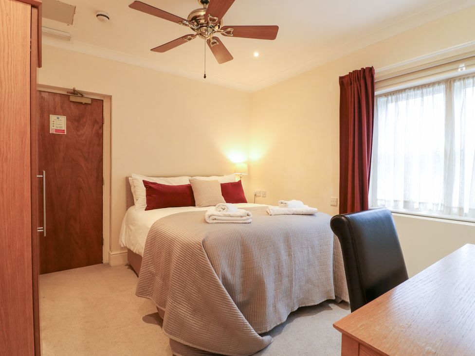 A bedroom with a bed and desk at Hambleton House in Castle Donington