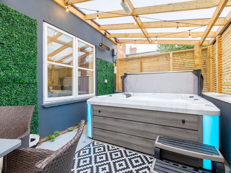 An outdoor area with a hot tub and seating at Hambleton House in Castle Donington