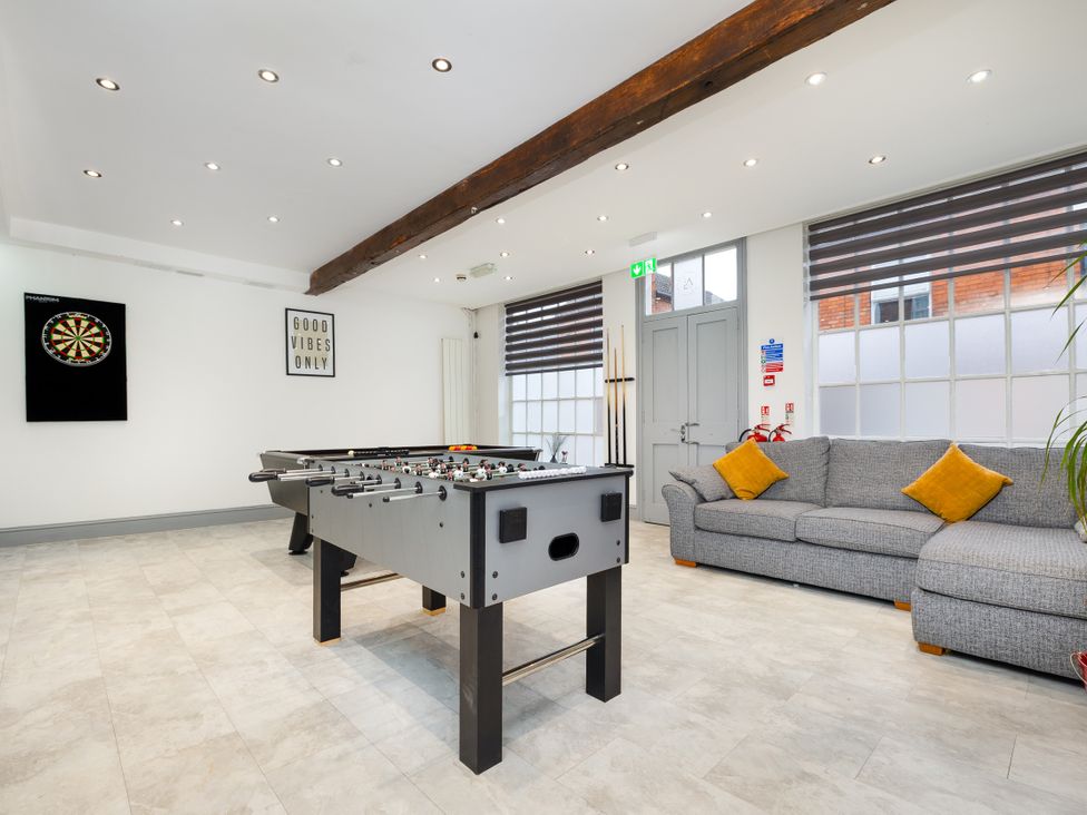 A game room with a foosball table and a dartboard at Hambleton House in Castle Donington