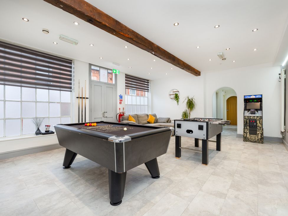 A game room with a pool table and foosball table at Hambleton House in Castle Donington