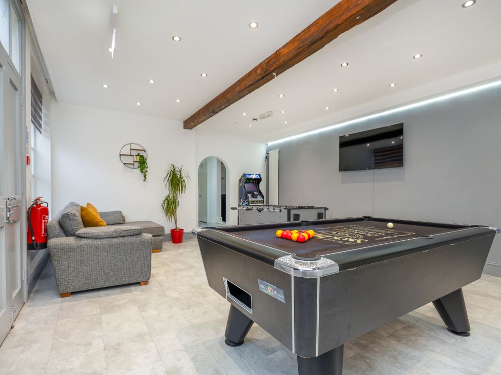 A game room with a pool table and arcade machine at Hambleton House in Castle Donington