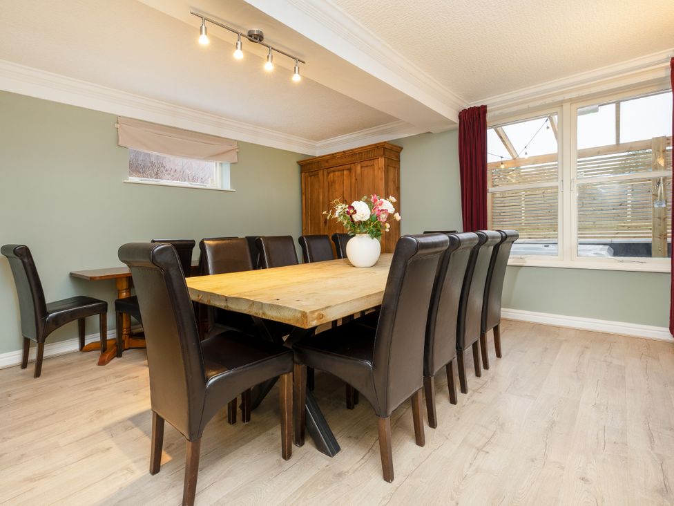 A dining room with a large table and chairs at Hambleton House in Castle Donington