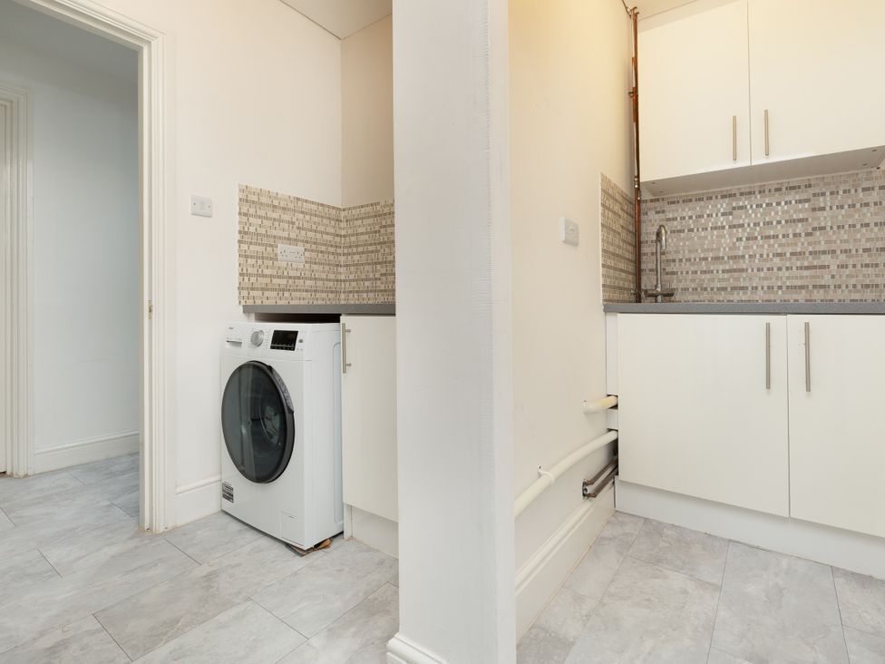 A laundry room with a washing machine and a sink at Hambleton House in Castle Donington