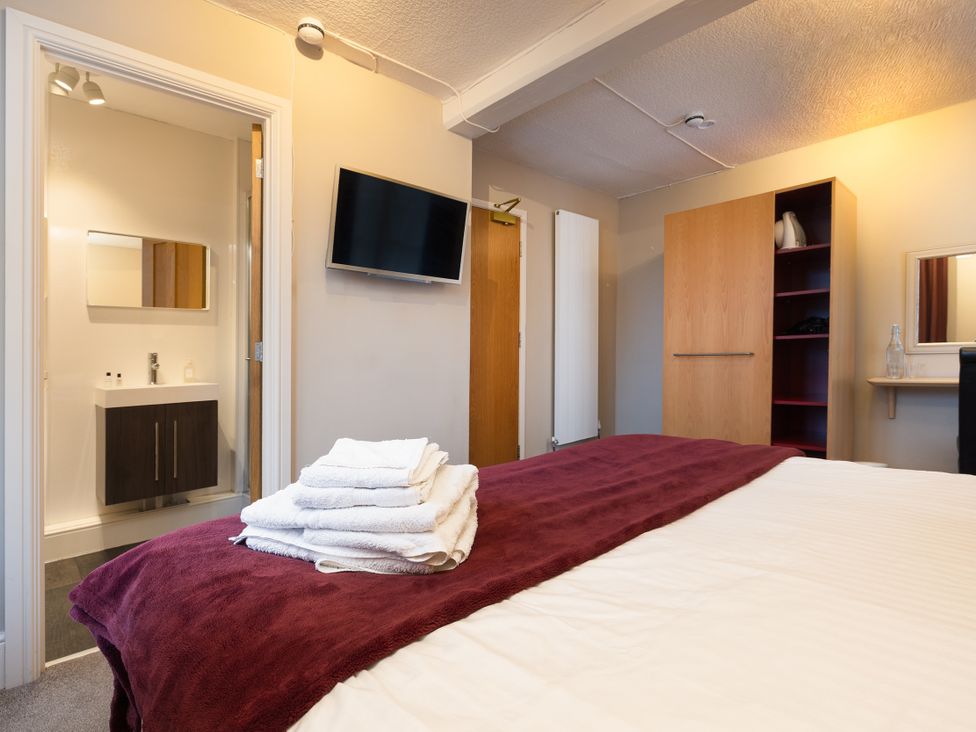 A bedroom with a bed and towels on top at Hambleton House in Castle Donington