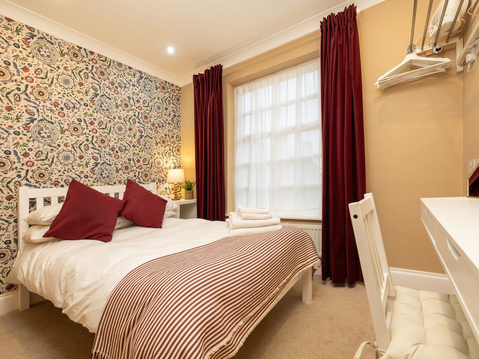 A bedroom with a bed, desk, and window at Hambleton House, Castle Donington