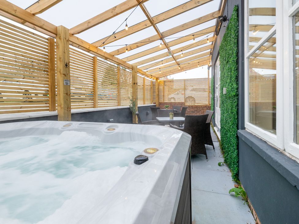 An outdoor area with a hot tub and seating at Hambleton House in Castle Donington