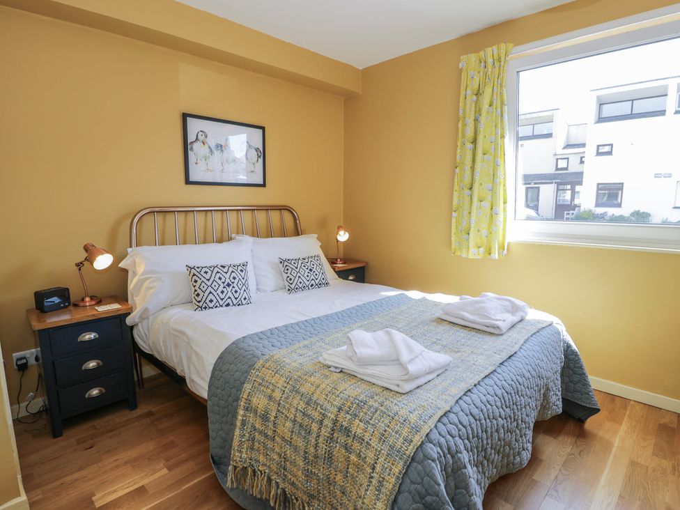 A bedroom with a bed and bedside lamps at 56C South Snowdon Wharf in Porthmadog