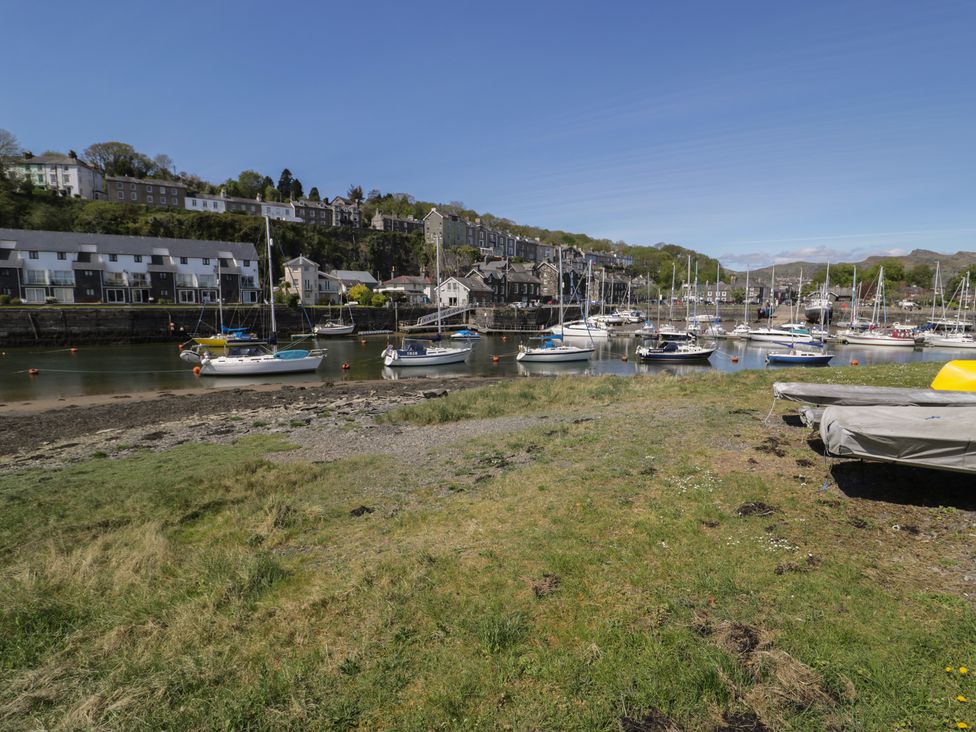 A view of boats in a marina with buildings and grass at 56C South Snowdon Wharf Porthmadog