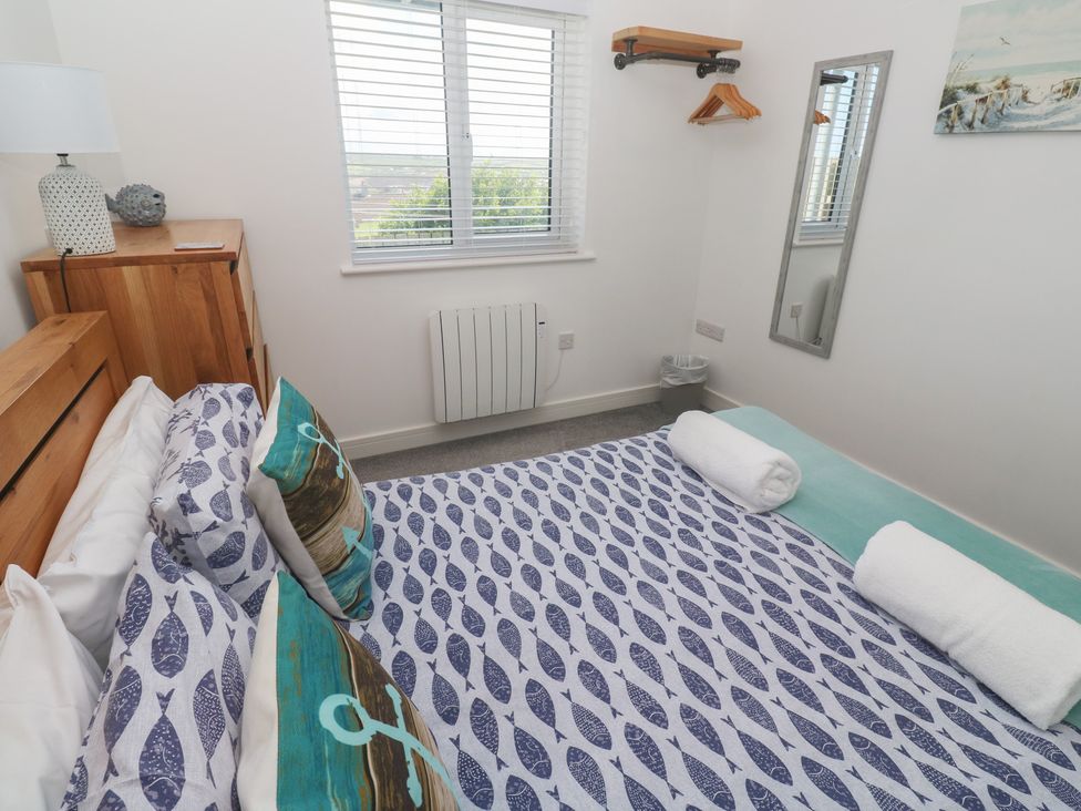 A bedroom with a bed and dresser at Sandpiper in Perranporth