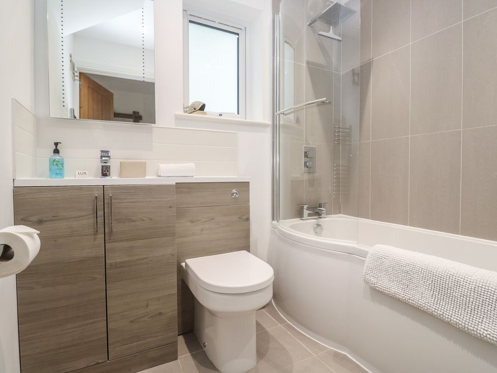 A bathroom with a bathtub and toilet at Sandpiper in Perranporth