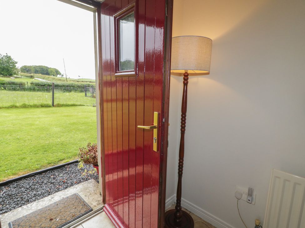 An entrance with a red door and a lamp at Shaws Hill Farmhouse, Kells, County Antrim