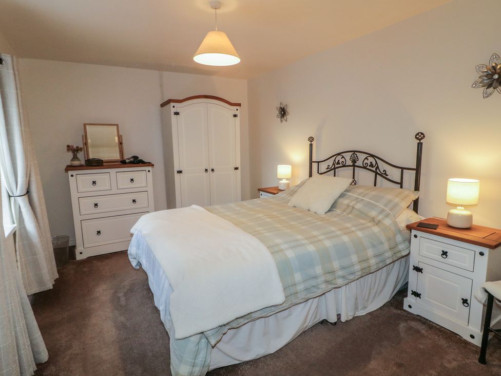 A bedroom with a bed and wardrobe at Shaws Hill Farmhouse in Kells, County Antrim