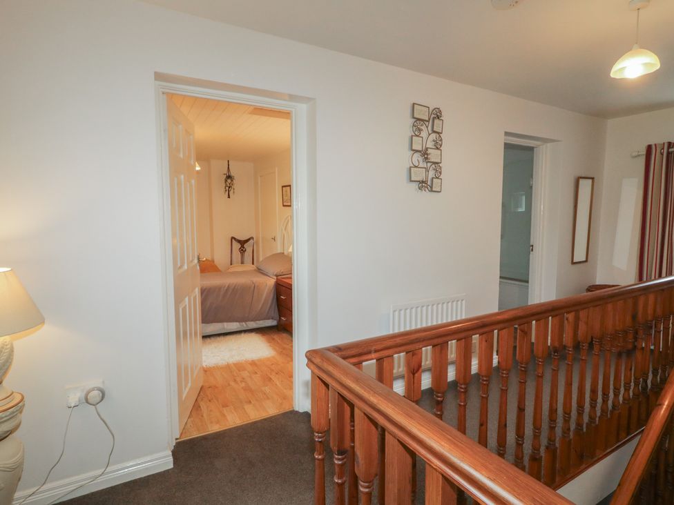 A hallway with a staircase and doors at Shaws Hill Farmhouse, Kells, County Antrim