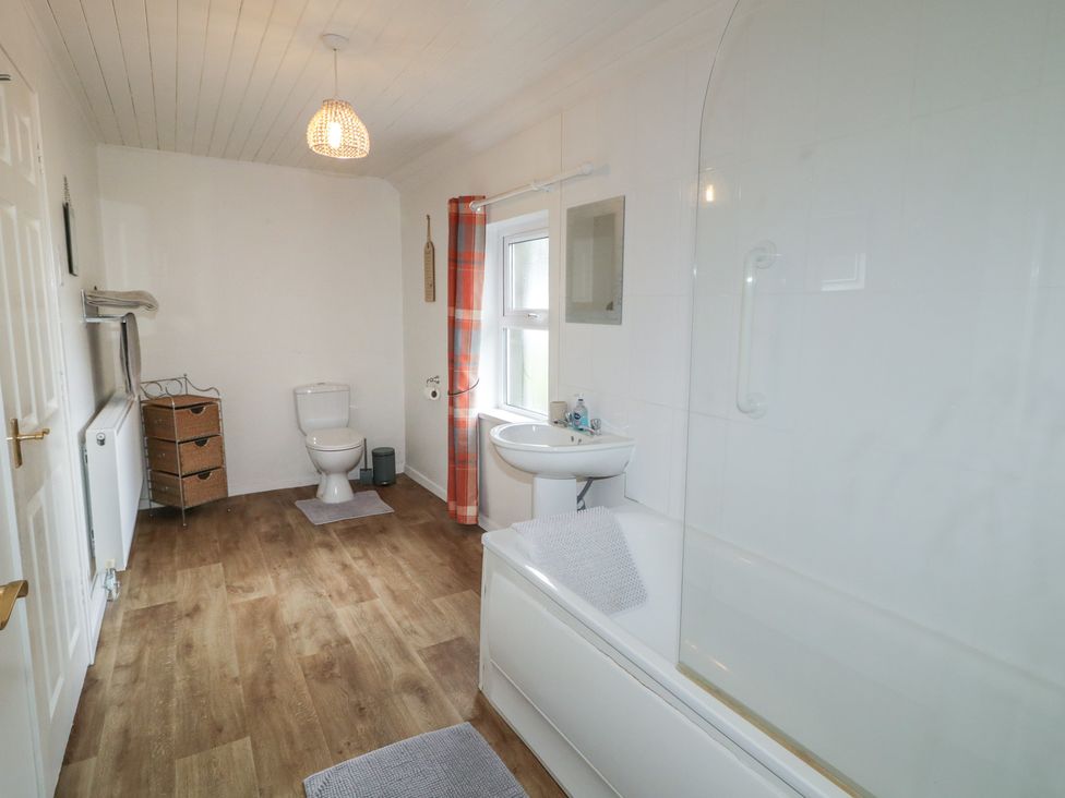 A bathroom with a bath tub, toilet, and sink at Shaws Hill Farmhouse, Kells, County Antrim