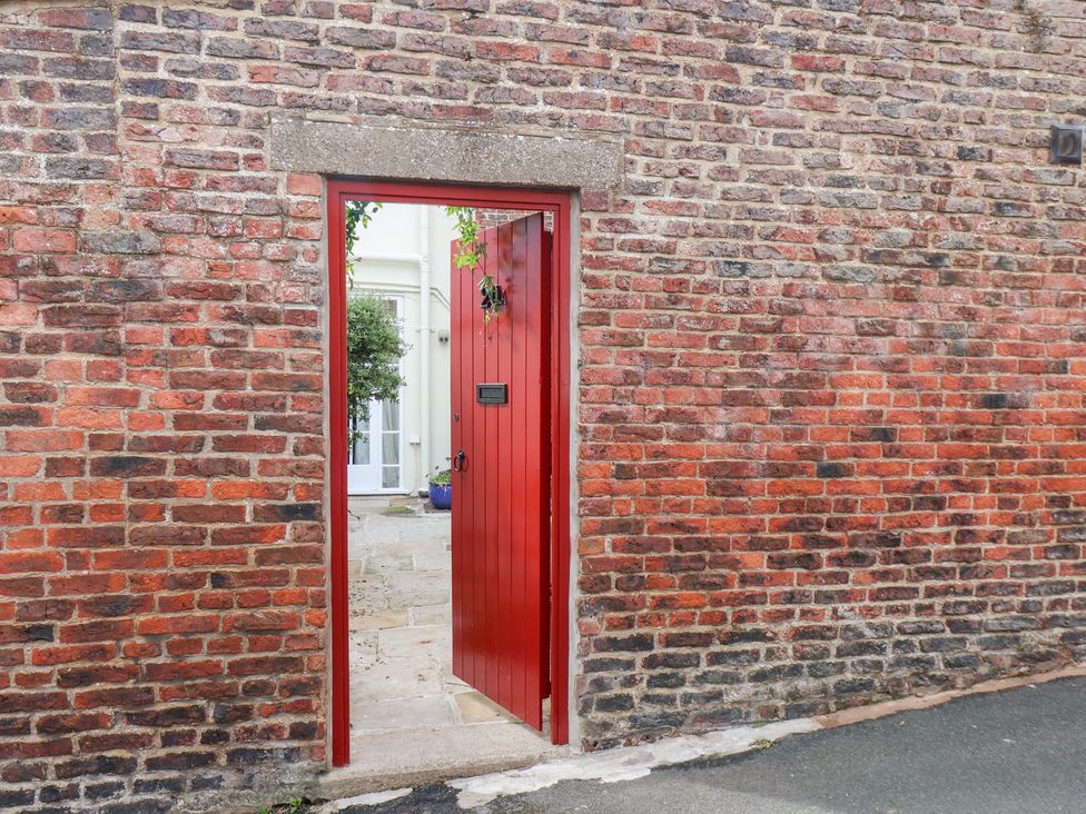 A red door opening to a courtyard at 20A St Hilda's in Whitby
