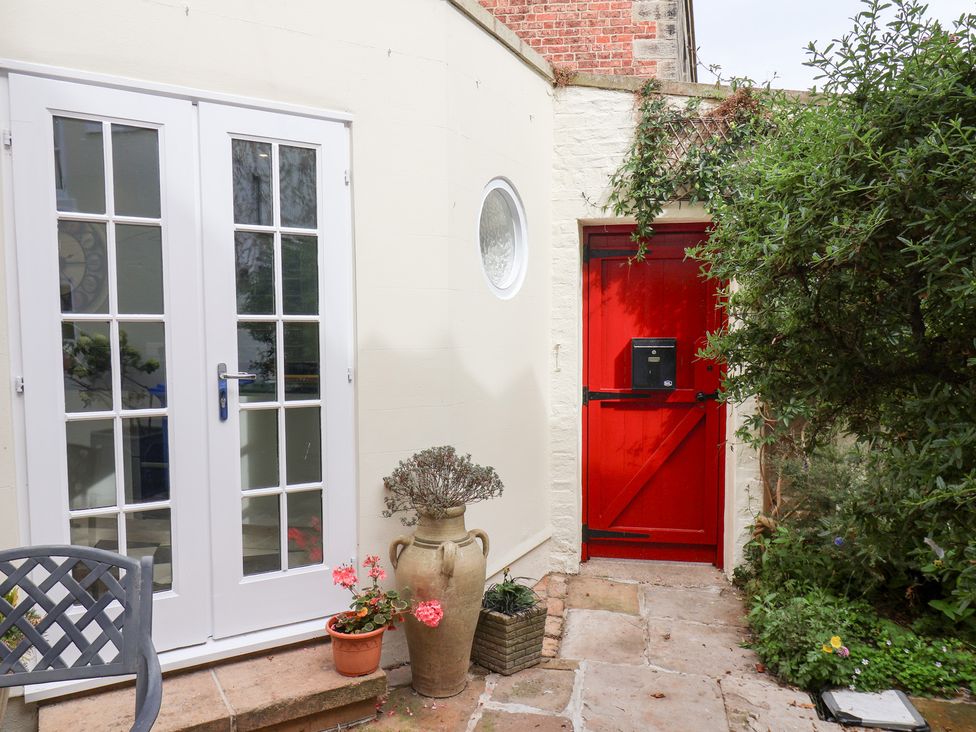 Double doors and a red door in a garden at 20A St Hilda's in Whitby