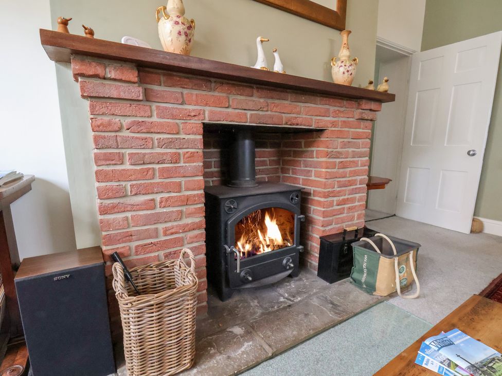 A living room with a fireplace and wood stove at 20A St Hilda's in Whitby