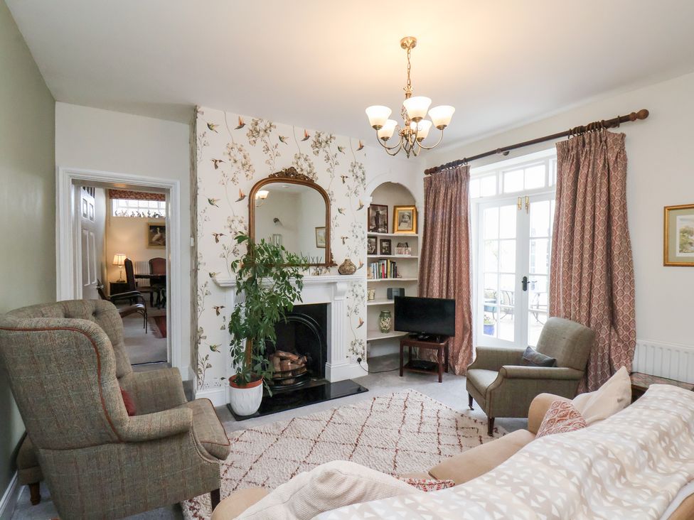 A living room with a sofa, armchair, and fireplace at 20A St Hilda's in Whitby