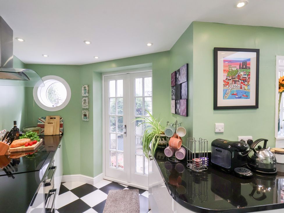 A kitchen with a countertop and a door leading outside at 20A St Hilda's in Whitby