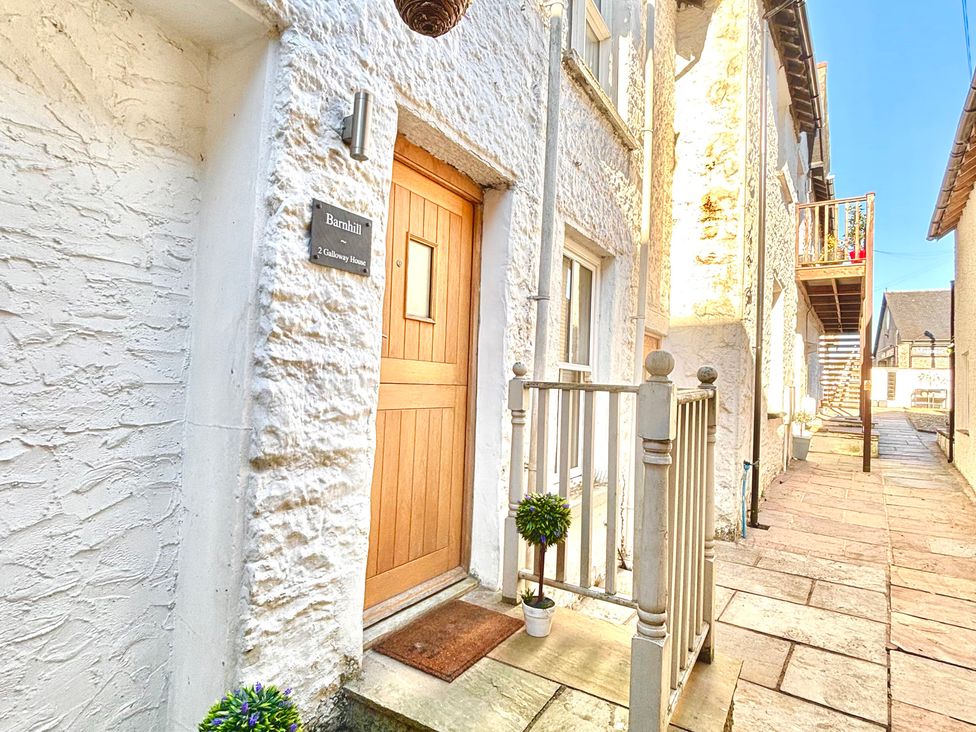A doorway with a house sign and planter at Flat 2 Galloway House in Kendal