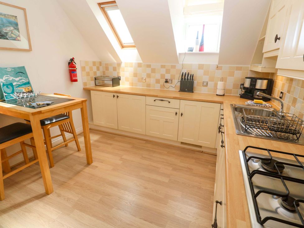 A kitchen with a table and stools at Meridian in Carbis Bay