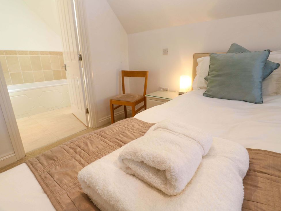 A bedroom with a bed and a chair at Meridian in Carbis Bay