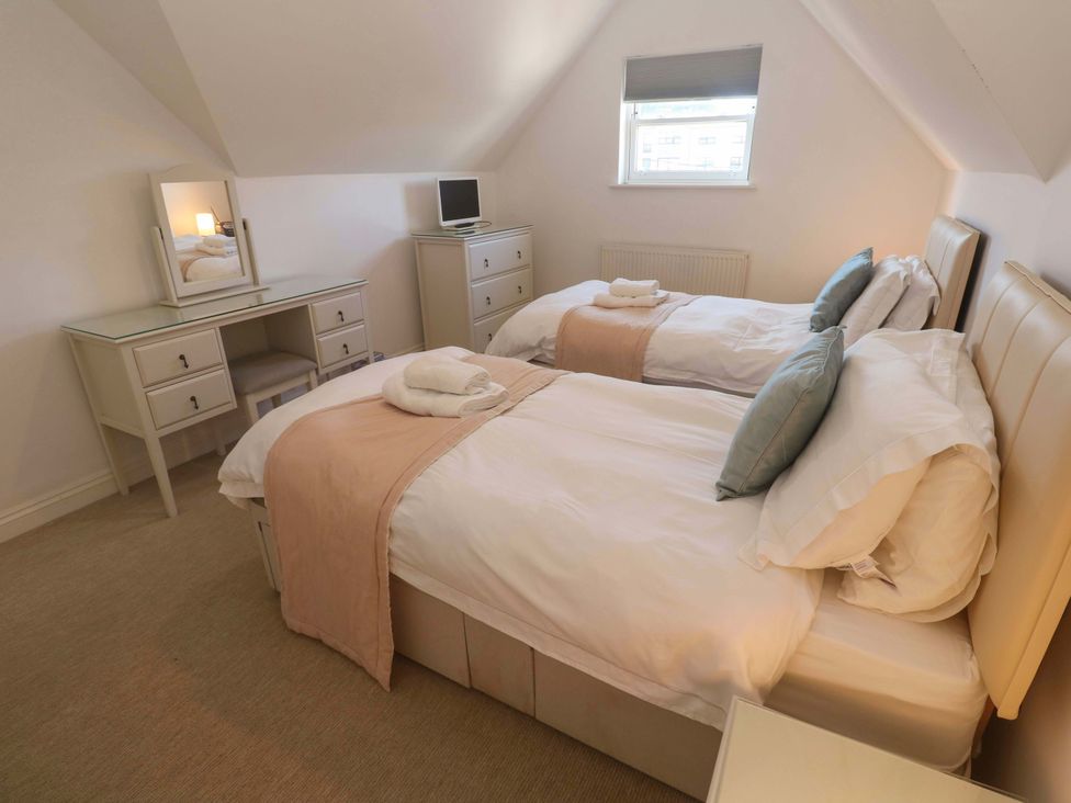 A bedroom with two beds and a desk at Meridian in Carbis Bay