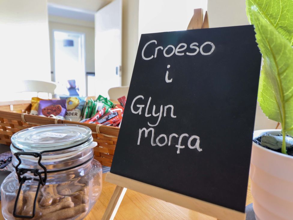A welcome sign and snacks in a kitchen at Glyn Morfa Harlech