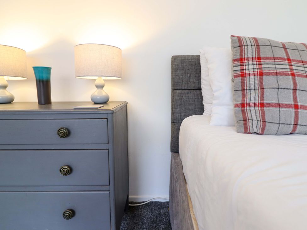 A bedroom with a bed and nightstand at Glyn Morfa in Harlech